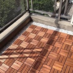 an outdoor deck with wooden tiles and metal railings