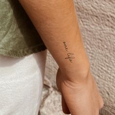 a person with a small tattoo on their left arm and the word love is written in cursive writing