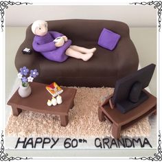 a birthday cake that is shaped like a couch and chair with a woman sitting on it