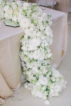 the table is set with white flowers on it