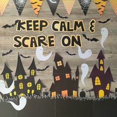 a wooden sign that says keep calm and scare on with halloween decorations in the background