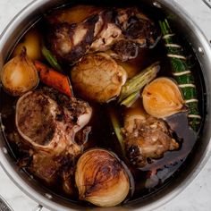 a pot filled with meat and vegetables on top of a table