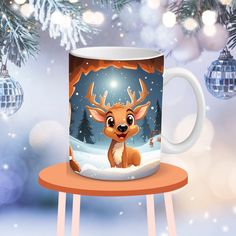 a coffee mug with a deer on it is sitting in front of a christmas tree