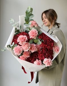 a woman holding a bouquet of flowers in her hands