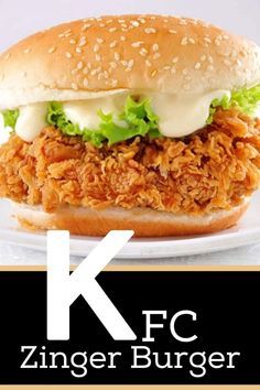 a chicken sandwich with lettuce and mayonnaise on a white plate next to the kfc logo