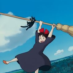 a woman holding onto a pole with a cat on it's back while another person watches