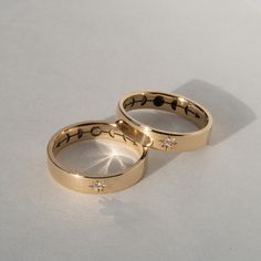 two gold wedding rings with diamonds on them