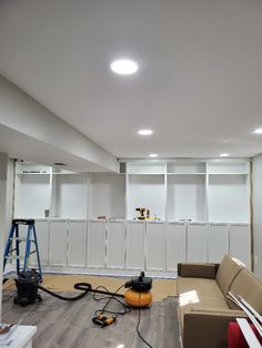 a living room that is being remodeled with white walls and cabinets in the back ground