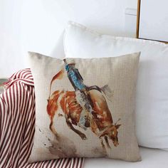 a pillow with a cowboy riding a horse on it next to some red and white striped pillows