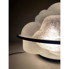 a lamp that is sitting on top of a table next to a black cord and some white balls