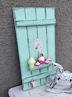 there is a horse statue next to cupcakes on a shelf in the shape of a door