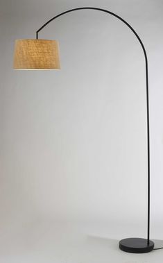 a black floor lamp with a beige shade