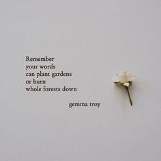 a white flower sitting on top of a piece of paper with words written below it