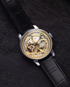 This customized Pobeda watch, with a 37 mm case, boasts a mesmerizing handcrafted skeleton dial that captures the beauty of celestial motifs. The intricate golden patterns etched into the dial evoke images of the cosmos, giving the timepiece an artistic and ethereal quality. The open-worked design of the dial not only enhances its aesthetic appeal but also provides a fascinating view of the inner mechanical workings, making it a true conversation piece. The watch's case is made from polished stainless steel, offering both durability and a sleek, modern look that contrasts beautifully with the ornate dial. This sturdy 37 mm case frames the celestial motif perfectly, ensuring that the dial remains the centerpiece of the design. Paired with a classic black leather strap, the watch exudes soph Gold Automatic Watches As Gift, Gold Automatic Watch For Gift, Gold Automatic Watches As A Gift, Gold Automatic Watch For A Gift, Gold Automatic Watches For Gift, Gold Skeleton Dial Watch Accessories, Gold Watch Accessories With Skeleton Dial, Gold Skeleton Dial Watch, Gold Watch With Skeleton Dial