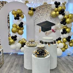 a room decorated with balloons, cake and graduation cap on the top of a table