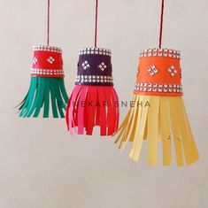 three different colored tassels hanging from strings