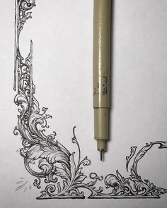 a pen is sitting on top of a piece of paper next to an ink drawing