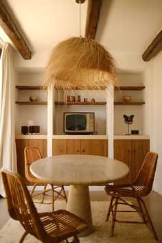 a table with chairs and a television in the background