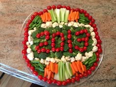 a platter with broccoli, carrots, cauliflower and cucumbers