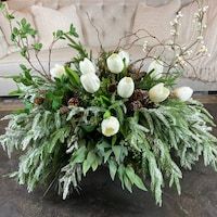 a vase filled with white flowers sitting on top of a table next to a couch