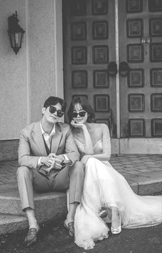 a man and woman sitting on the steps with their faces painted like people wearing masks