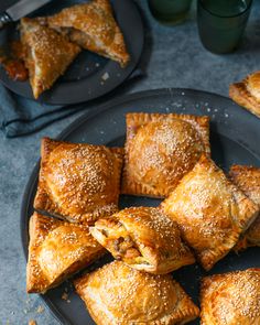 some pastries are on a black plate and one is cut in half to show the filling