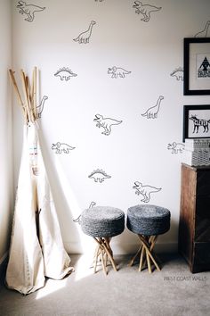 two stools in front of a wall with dinosaur decals on it and a teepee tent