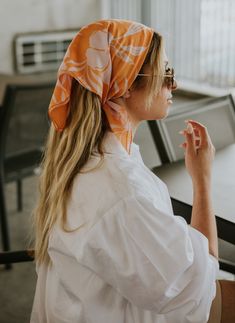 The "Hawaiian Breeze Head Scarf" by TUK captures the essence of tropical paradise with its vibrant design. Featuring bold, stylized floral patterns in soft lavender against a warm orange backdrop, this headscarf exudes a sense of laid-back island charm. Perfect for adding a touch of the tropics to any outfit, this scarf is a beautiful blend of style and comfort, making it a versatile accessory for any occasion. Whether you're looking to elevate your everyday look or bring a bit of vacation vibes Beach Bandana Hair, Hair Handkerchief Style, Scarf Outfits Summer, Summer Headscarf, Hair Scarf Hairstyles, Hair Scarf Ideas, Head Scarf Outfit, Scarf Outfit Summer, Triangle Light