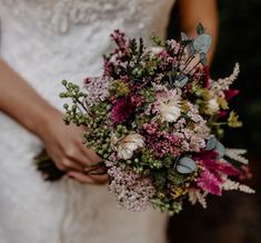 a bride holding a bouquet of flowers in her hands