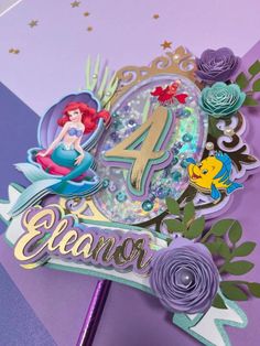 a close up of a birthday card with the number four on it and ariel the mermaid