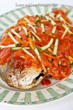 a plate topped with fish covered in sauce and veggies