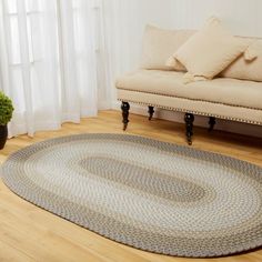 a living room area with a couch, chair and rug on the hardwood flooring