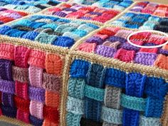 a multicolored crocheted blanket sitting on top of a table