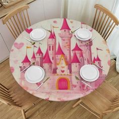 the table is set with white plates and pink castle napkins on top of it