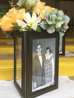 an old photo is placed in a vase with flowers