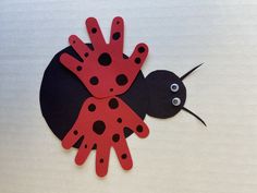 a paper cut out of a lady bug with black dots on it's body