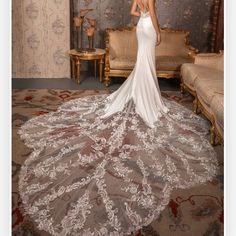 a woman in a white wedding dress standing on a carpeted area with an ornate wallpaper