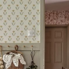 a basket sitting on top of a table in front of a wallpapered wall