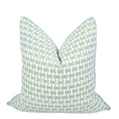 a light blue and white pillow with an intricate design on the front, sitting on a white background