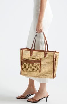 Panels of woven and crocheted raffia bring a summery sensibility to this spacious tote designed with logo topstitching and leather trim. Open top Shoulder straps Exterior zip pockets Interior wall pockets Structured silhouette with flat base for stability Raffia/leather Imported Designer Handbags Natural Straw Tote Bag With Leather Trim, Natural Straw Bag With Leather Trim, Casual Style, Luxury Open Weave Straw Bag For Summer, Luxury Summer Straw Bag With Open Weave, Casual Straw Bag With Leather Trim For Vacation, Brown Crochet Bag With Intrecciato Weave For Vacation, Casual Straw Tote Bag With Leather Trim, Beige Crochet Bag With Intrecciato Weave For Shopping, Chic Crochet Bag With Intrecciato Weave In Natural