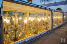 an old fashioned chandelier is reflected in the glass window on the side of a building