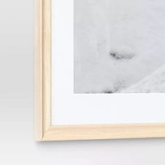 a white framed photograph hanging on the wall next to a black and white cat's paw