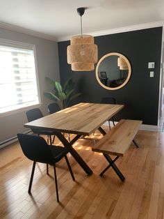 a dining room table and chairs with a bench in front of the mirror on the wall