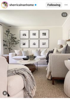 a living room filled with white furniture and pictures on the wall above it's coffee table