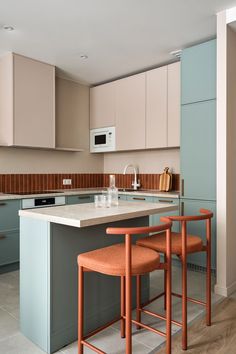 a kitchen with an island and two stools in front of the countertop area