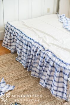 an unmade bed with blue and white checkered bedspread on the floor