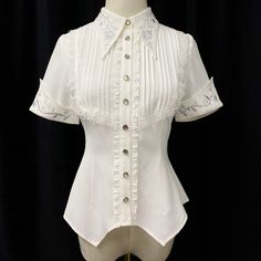 An embroidered blouse that looks like an aristocratic lady from medieval Europe. A cross and a rose are embroidered on the collar, and ivy is also embroidered on the cuffs. The back is decorated with lacework, and the chest is decorated with ruffles, pleats, and lace embroidery. For a young lady with a gorgeous atmosphere. 
 
 

 

 
 
 Color 
 
 White 
 Black 
 
 
 Size 
 
 
 S size 
 
 Length: 60cm 
 Shoulder width: 36cm 
 Bust: 86cm 
 Waist: 68cm 
 Sleeve length: 21.5cm 
 
 M size 
 
 Length: Spring Season Gothic Formal Tops, Elegant Short Sleeve Lace Blouse, White Fitted Victorian Blouse, Elegant Blouse With Peter Pan Collar And Buttons, Elegant Lace Tops With Collar, Fitted White Victorian Blouse, Elegant White Tops With Lace Collar, White Blouse With Floral Embroidery And Doll Collar, Elegant White Top With Lace Collar