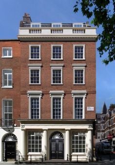 an old brick building with white columns and windows