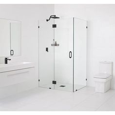 a white bathroom with a walk in shower next to a toilet