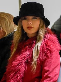 a woman wearing a red coat and black hat